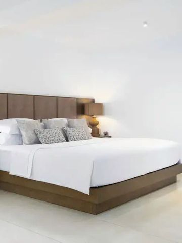 Minimalistisch eingerichtetes Zimmer mit großem Bett und warmen Farbtönen