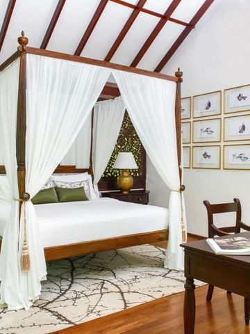 Geräumiges Schlafzimmer mit Himmelbett und einem Schreibtisch aus Holz