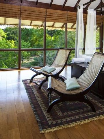 Elegante Sitzgelegenheiten in einem hellen Raum mit großer Fensterfront und grüner Aussicht