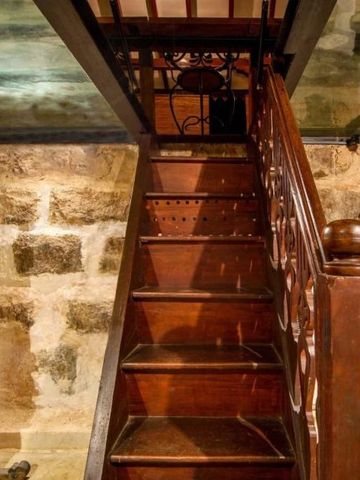 Historischer Weinkeller mit rustikalen Holztreppen und Steinwänden