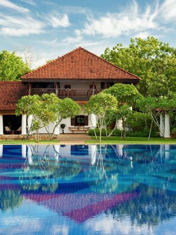 Außenansicht eines luxuriösen Anwesens mit Pool und grüner Umgebung