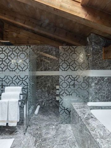 Edles Badezimmer mit Marmorverkleidung und Holzbalkendecke