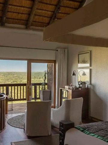 Helles Hotelzimmer mit Holzdecke und Zugang zum Balkon