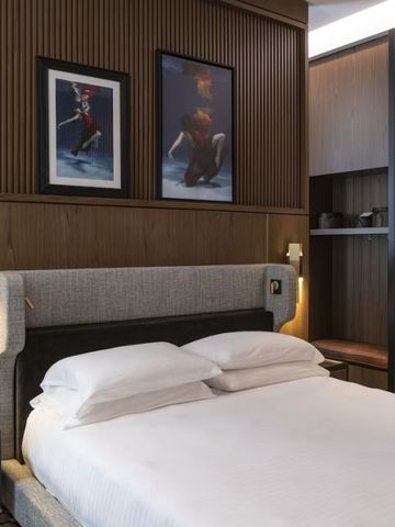 Hotelzimmer mit edlem Holzdesign und Kunstwerken an der Wand.