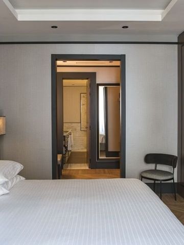 Modernes Hotelzimmer mit Blick auf das Badezimmer durch eine offene Tür.