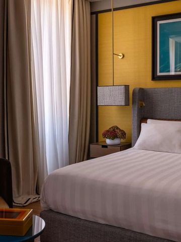 Gemütliches Hotelzimmer mit Kunst an der Wand und weichen Stoffen.