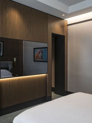 Modern eingerichtetes Hotelzimmer mit Holzvertäfelung und Kunstwerken