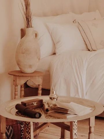 Zeltzimmer mit Beistelltisch, Vase und luxuriöser Bettwäsche.