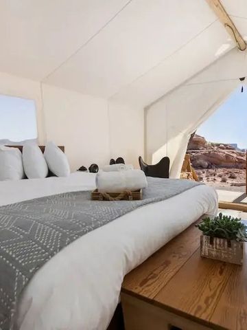 Elegantes Zeltzimmer mit Bett und Aussicht auf die naturbelassene Umgebung