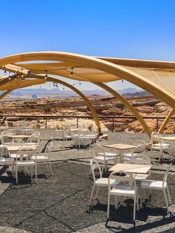 Outdoor-Essbereich mit markantem Holzdesign und Wüstenpanorama im Hintergrund