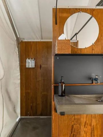 Modernes Waschbecken in einem rustikalen Badezimmer mit Holzdetails.