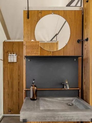 Gut ausgestattetes Waschbecken in einem modernen rustikalen Badezimmer.