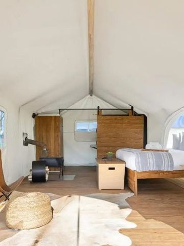 Geräumiges Zelt mit Doppelbett. Helle Einrichtung und stilvolles Dekor.