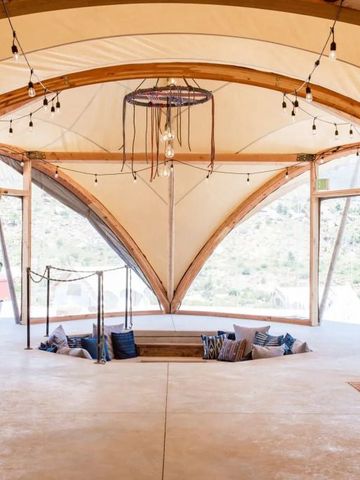 Lounge im glamping-Stil mit gemütlicher Sitzgelegenheit in heller Zeltstruktur