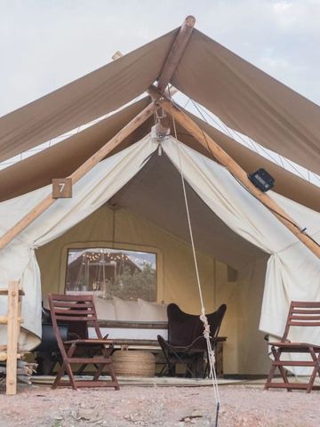 Offenes Glamping-Zelt mit bequemen Sitzmöglichkeiten im Freien