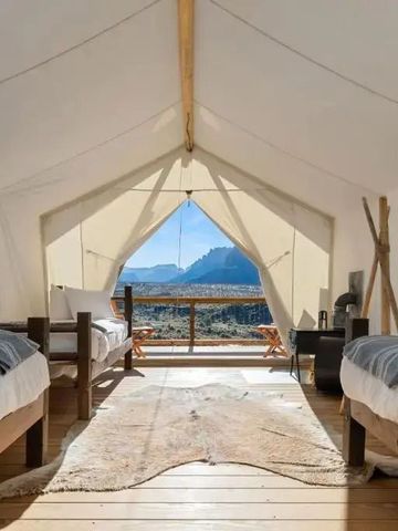 Geräumiges Zelt mit zwei Betten und herrlichem Ausblick auf Berglandschaft.