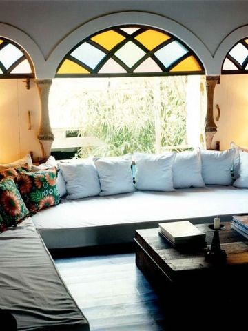 Gemütliche Sitzecke mit bunten Kissen und Buntglasfenster