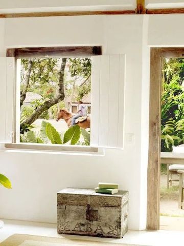 Heller Raum mit Blick ins Grüne durch ein offenes Fenster