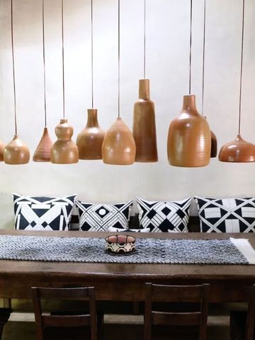 Rustikales Esszimmer mit hängenden Terrakotta-Lampen und Holztisch.