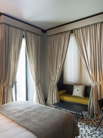 Elegantes Hotelzimmer mit großen Fenstern und luxuriösen Vorhängen