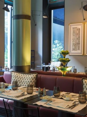 Eleganter Speiseraum mit modernen Tischen und Stühlen in warmen Farben