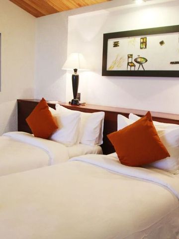 Doppelzimmer mit zwei Betten und dekorativen Kissen