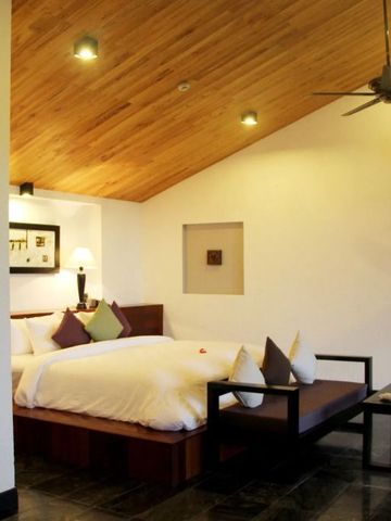 Geräumiges Schlafzimmer mit Holzakzenten und Sitzbereich