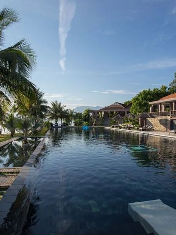 Infinity-Pool umgeben von Palmen, mit Blick auf die Lagune