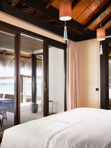 Luxuriöses Schlafzimmer mit Blick auf das Meer und Zugang zu einer privaten Terrasse.