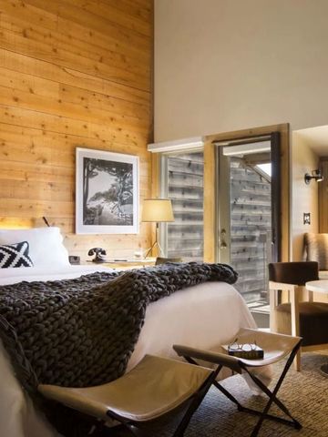 Gemütliches Schlafzimmer mit Holzwänden und direktem Zugang zur Terrasse.