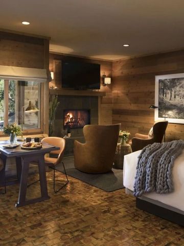 Luxuriöse Suite mit Kamin und modernen Möbeln in warmen Erdtönen.