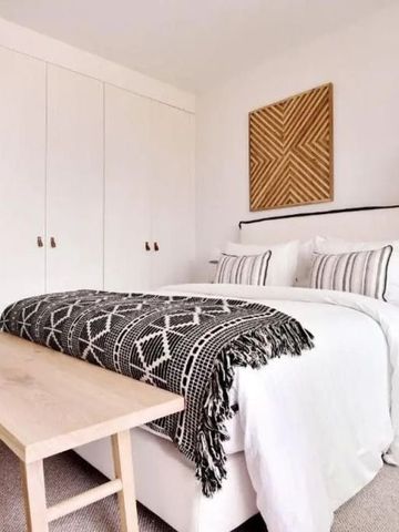 Modernes Schlafzimmer mit stilvoller Wandkunst und Akzentdecke