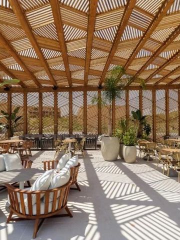 Sonnendurchflutete Terrasse mit Holzdach und modernen Sitzmöbeln