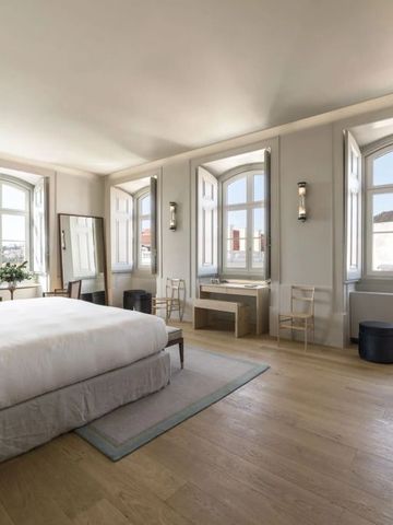 Helles Hotelzimmer mit eleganten Holzböden und großen Fenstern