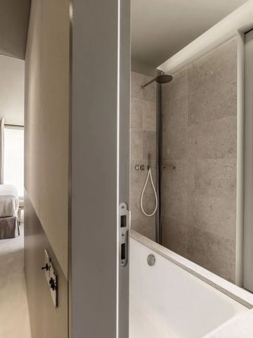 Badezimmer mit Badewanne und separatem Schlafbereich im Hotel