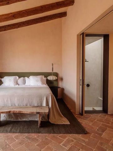 Geräumiges Schlafzimmer mit Holzbalkendecke und luxuriösem Doppelbett