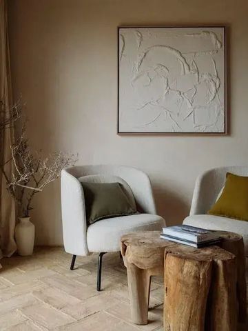 Gemütliche Sitzecke mit stilvollen Sesseln und kunstvoller Wanddekoration