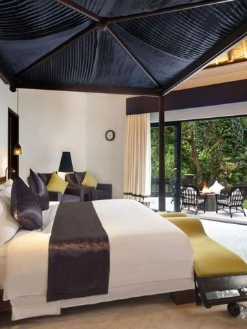 Elegantes Schlafzimmer mit Baldachinbett und großer Glasfront zur Terrasse