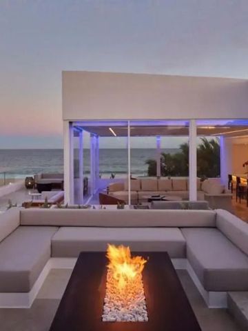 Lounge im Freien mit Feuerstelle und Meerblick bei Sonnenuntergang