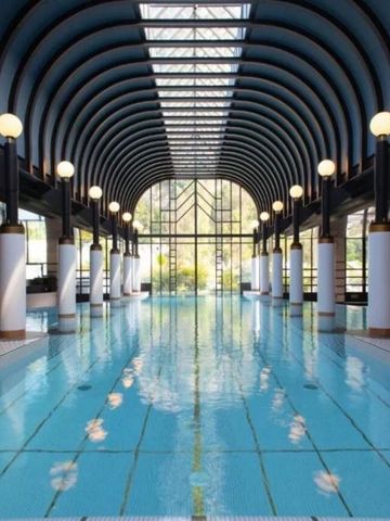 Luxuriöser Innenpool mit eleganter Deckenkonstruktion und natürlichem Licht