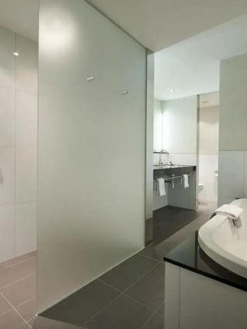 Luxuriöses Badezimmer mit großer Badewanne und glatten Oberflächen