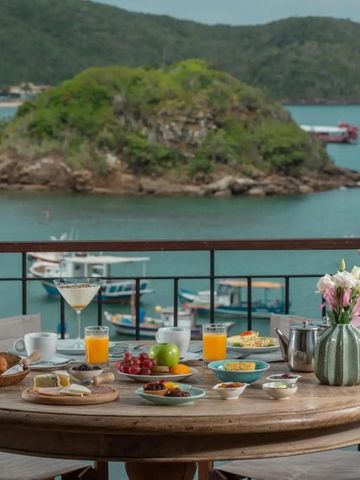 Frühstück auf Terrasse mit Meerblick und grüner Insel im Hintergrund im Hotel Vila d'este