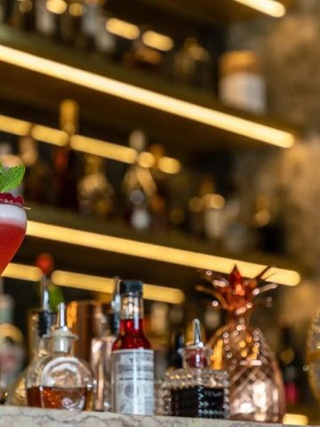 Cocktailbar mit einer Auswahl an Getränken und einem dekorativen Cocktail