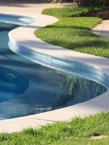 Eleganter Swimmingpool mit geschwungenen Linien im Garten