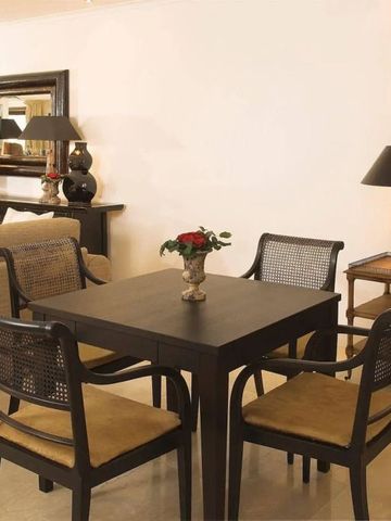 Gemütlicher Essbereich mit stilvollen Holzmöbeln und Blumenarrangement