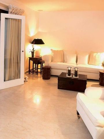 Elegantes Wohnzimmer mit hellen Möbeln und Zugang zur Terrasse