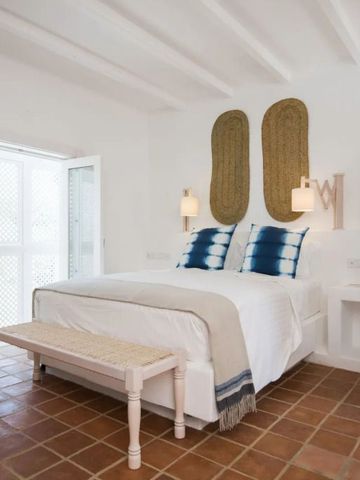 Einladendes Schlafzimmer mit Terrakottaboden und stilvollen Dekorelementen