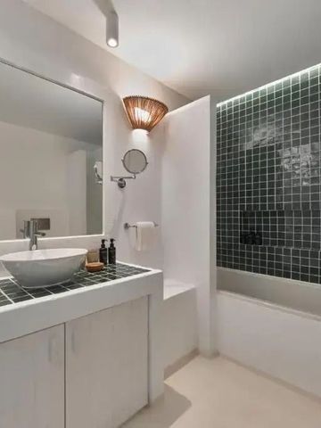 Elegantes Badezimmer mit grünen Kacheln und moderner Einrichtung