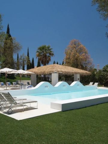 Infinity-Pool mit Liegestühlen und Sonnenschirmen im Garten