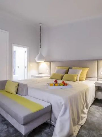 Komfortables Schlafzimmer mit heller Einrichtung und Sitzgelegenheit